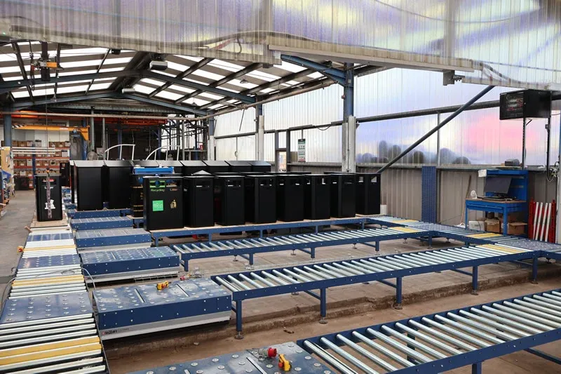 Rollenförderanlagen für die Stadtmöbelherstellung Multiple roller conveyor lines transporting street furniture litter bins through a manufacturing facility
