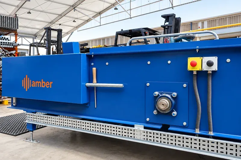 Amber Industries Förderbandantriebs- und Steuerungstechnik Close-up of Amber Industries blue conveyor equipment showing drive components and emergency stop controls